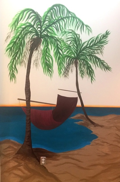 mural with a hammock and palm trees on the beach